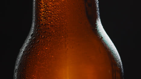 Close-Up-Of-Condensation-Droplets-Running-Down-Revolving-Bottle-Of-Cold-Beer-Or-Soft-Drink